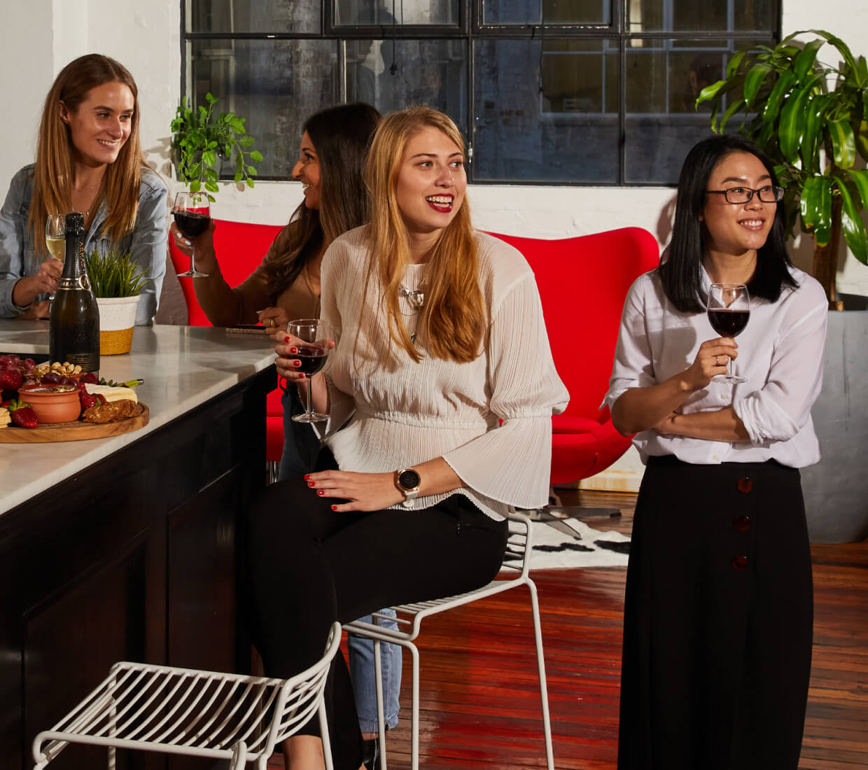 Four people holding drinks in a bar