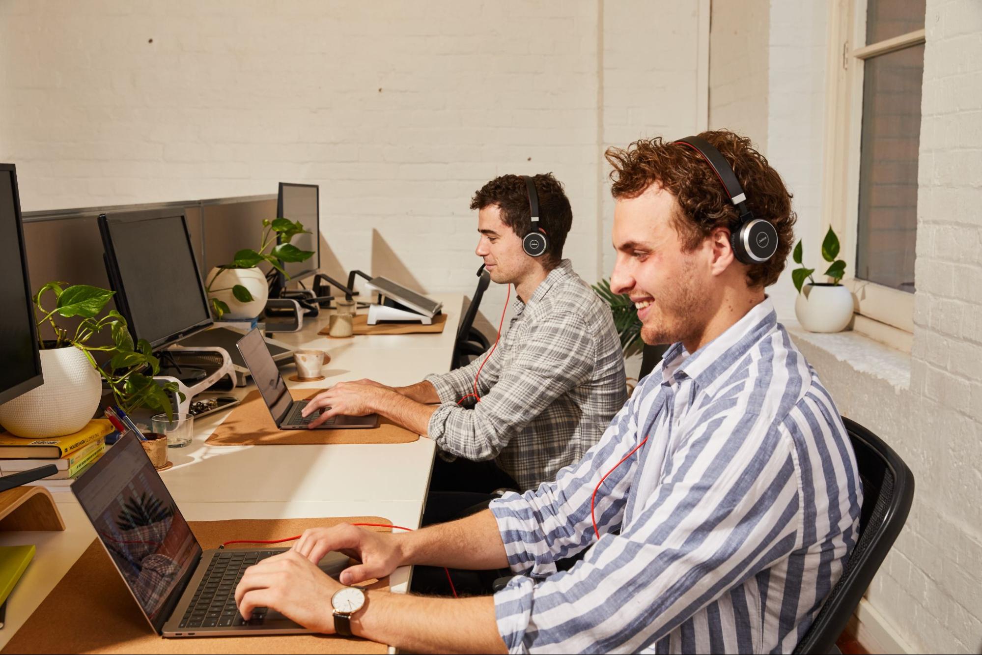 two employees sitting at their desk working