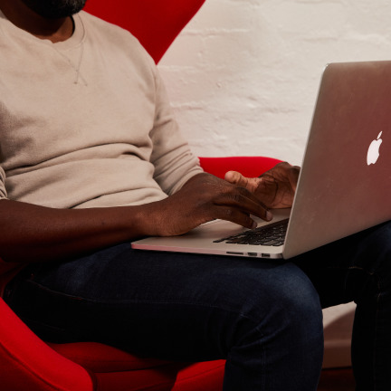 A man typing on his macbook.