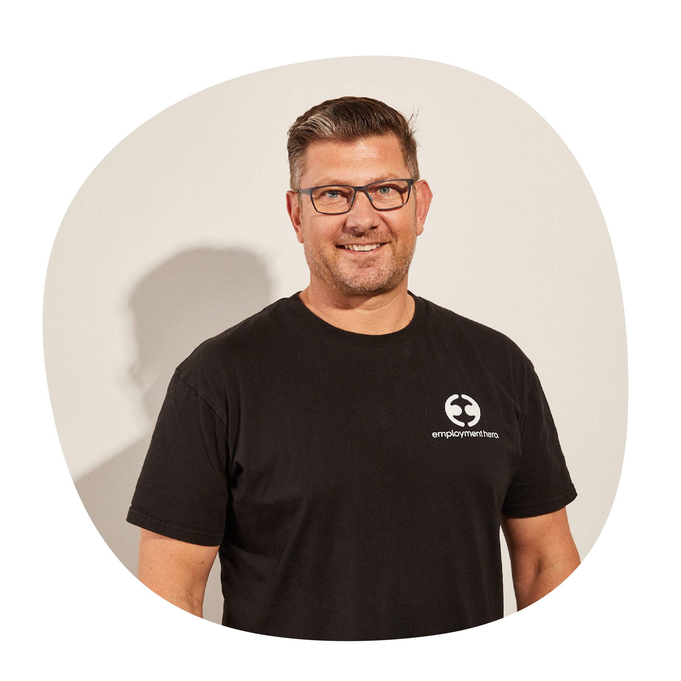 Ben Thompson wearing a black t-shirt with Employment Hero's white logo on the side. 