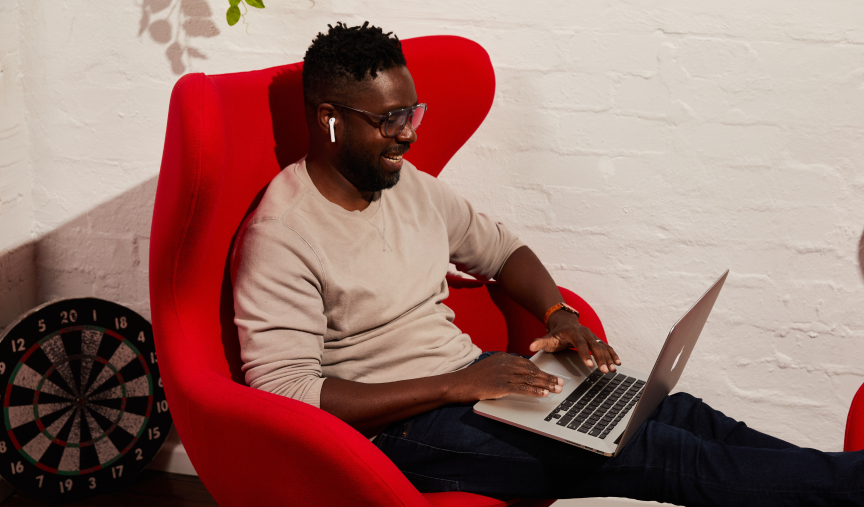 employee sitting on a sofa chair with his laptop