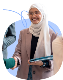 A woman wearing hijab smiling while shaking hands with a business partner.